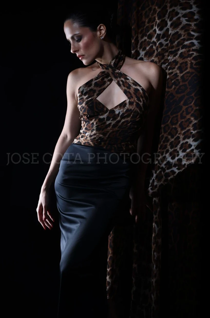 Vestido de top animal print y falda de satín negro en luz dramática